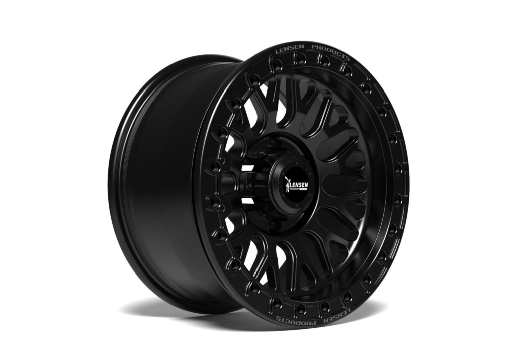 Close-up van een zwarte CNC forged beadlock velg met boutring gemonteerd op een lifted 4x4 terreinwagen in het terrein.