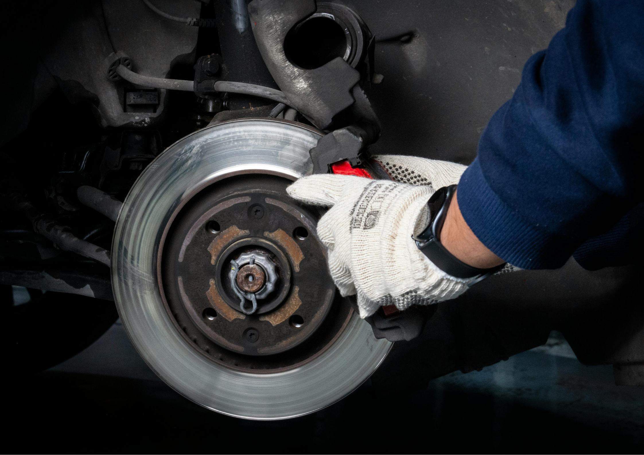 Close-up van een grote gesleufd remschijf met rode remklauw achter een beadlock velg van een lifted 4x4 terreinwagen.
